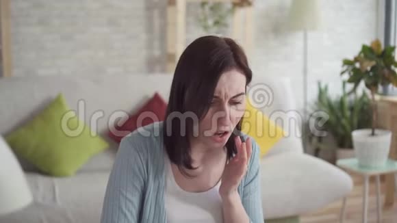 靠近一个年轻的女人抹着皲裂的嘴唇在坐着疗伤视频的预览图