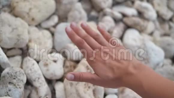 一个女人把手放在海洋上的石头表面放松放松4k视频的预览图