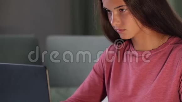 穿着紫色运动衫的浅黑色微笑着看着现代笔记本电脑视频的预览图