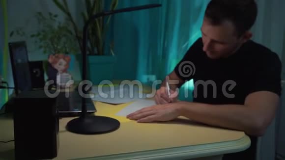 粉刺男想写什么写在纸上的信里坐在桌子旁手里拿着笔视频的预览图