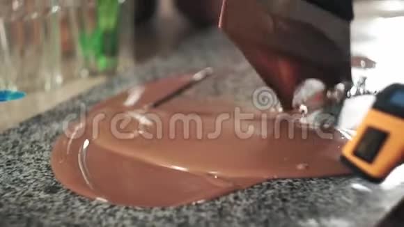 用温度计和抹刀在大理石上回火巧克力视频的预览图