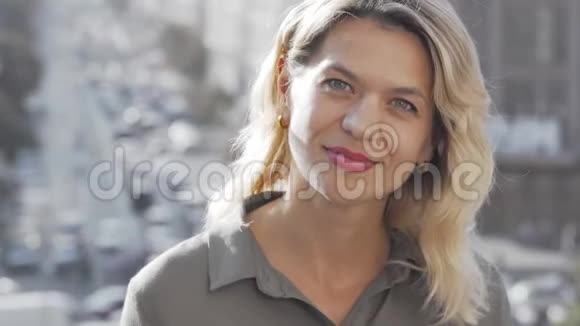 城市背景下美丽成熟的女人对着镜头微笑视频的预览图