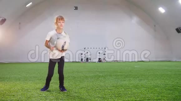 室内足球场一个玩球的小女孩把它扔上去视频的预览图