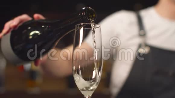 围裙的酒保把香槟倒在玻璃杯里关上视频的预览图
