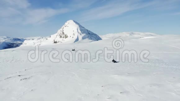 Drone跟着一个人在瑞典北部的AtoklintenJoesjoLappland附近的冬季山区驾驶雪车视频的预览图