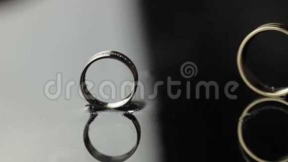婚礼戒指在黑色白色的水面上新郎的戒指滚向新娘戒指视频的预览图