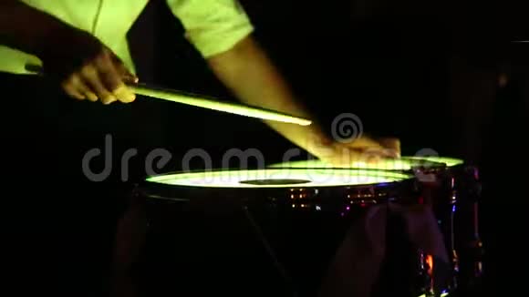 鼓手在轻鼓上演奏棍棒的平均节奏四周很黑视频的预览图