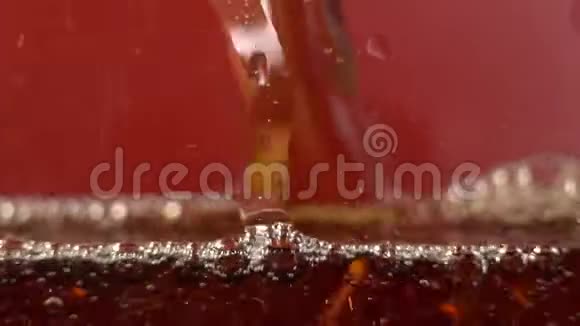 红色背景上的气泡闪闪发光在一杯冷可乐里的气泡无缝地上升视频的预览图