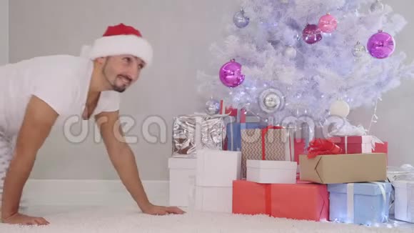 古怪的父亲晚上偷偷溜到圣诞树上打开礼物从里面拿出一颗糖果吃了它没有人注意到它视频的预览图