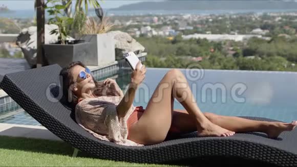 在酒店顶层的泳池边悠闲的女性自拍视频的预览图