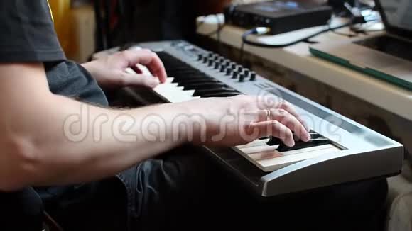 一个穿着黑色t恤的白人在合成器上演奏他最喜欢的曲子视频的预览图