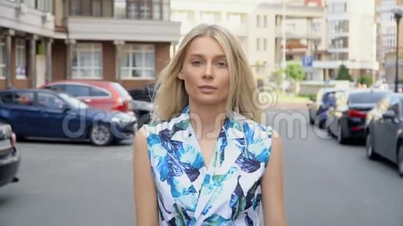 穿着夏装的金发美女在停车场摆姿势摄像机线路女人散步视频的预览图