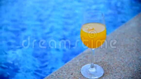 在游泳池的室外倒入健康的橙汁以新鲜美味和甜蜜的软饮料玻璃新鲜的橙果园视频的预览图