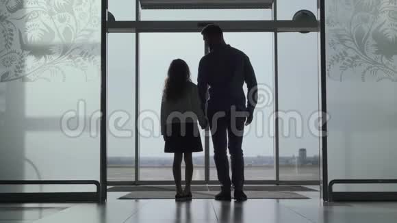站在机场门口看跑道的成年男子和小女孩的后景轮廓父亲和视频的预览图