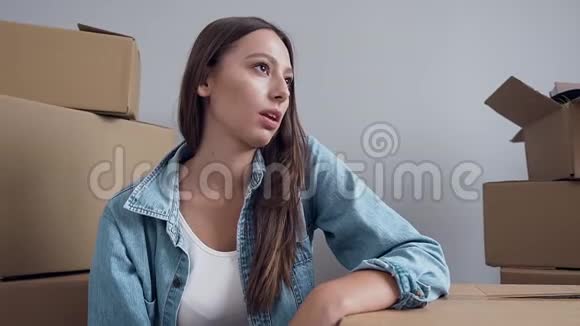 搬迁后一位漂亮的疲惫的年轻女子躺在空的新公寓里盒子上里面有许多盒子视频的预览图