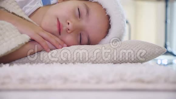 可爱的视频小女孩戴着圣诞帽睡觉看起来很可爱视频的预览图
