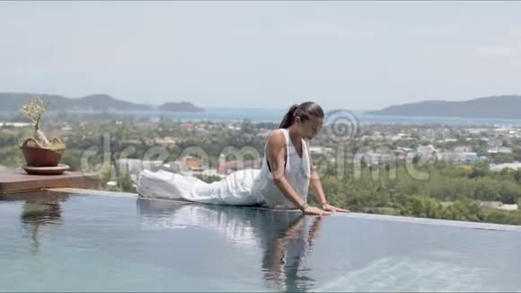 成年女性在海边的度假胜地与游泳池边平衡运动视频的预览图