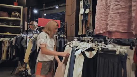 金发女孩在女子服装店挑选东西视频的预览图