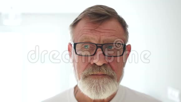 戴着眼镜和白色t恤的悲伤的退休者成熟的男人会考虑他的问题沮丧的状态心理视频的预览图
