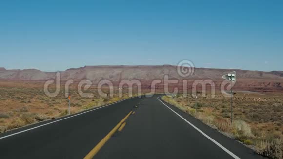 在红岩背景下在公路上远行穿越沙漠视频的预览图