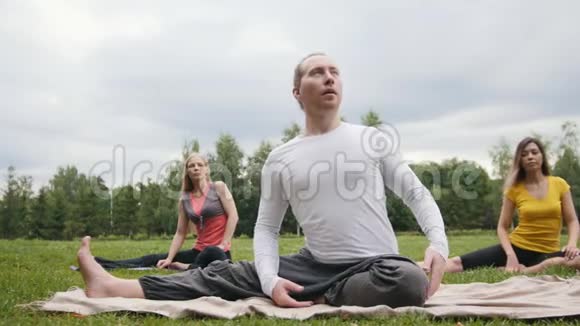 教练在公园教女子瑜伽弹性训练视频的预览图