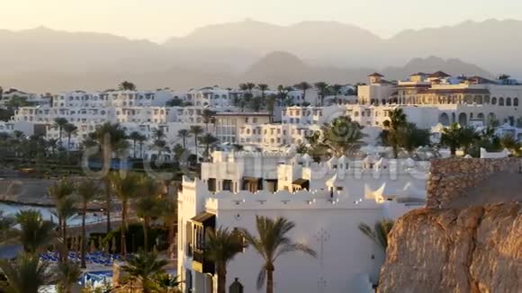 豪华度假酒店公寓全景阳台和棕榈靠近海滩背景是山脉美丽美丽视频的预览图