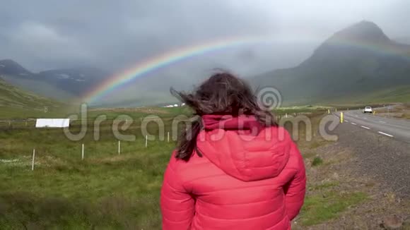 一个女孩用手机拍摄一条美丽的彩虹视频的预览图