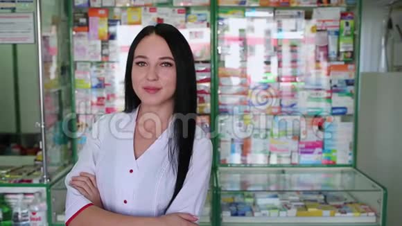 一位美丽的黑发女子在一家药店橱窗的背景下摆姿势当药剂师视频的预览图
