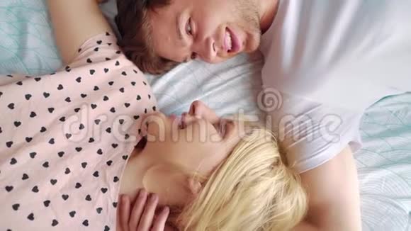 镜头旋转的可爱夫妇面对面躺在床上放大视频的预览图