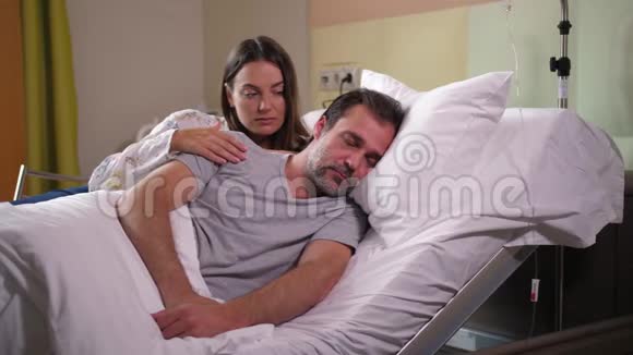 不安的妻子在门诊病房爱抚生病的男人视频的预览图
