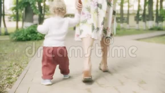 夏天小女孩牵着妈妈手在公园散步视频的预览图