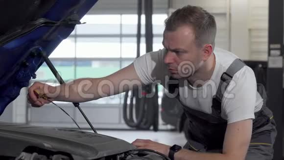 成熟的汽车修理工用敞篷汽车检查机油视频的预览图