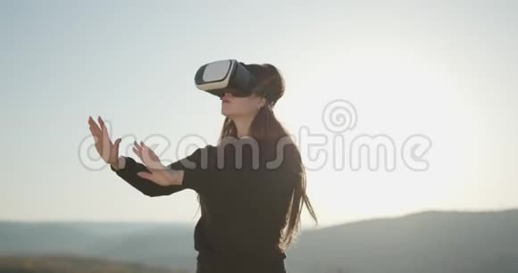 可爱的女孩使用3D虚拟现实耳机虚拟现实游戏女士戴着VR耳机女人用手摸东西视频的预览图