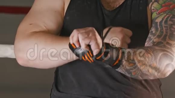 一个肌肉发达的男人手腕上有带条纹的弹力绷带视频的预览图