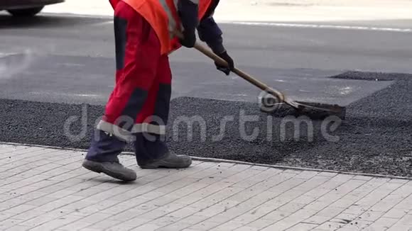 工人在道路施工现场平整新鲜沥青道路工程视频的预览图