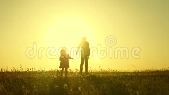 日落时分快乐的孩子和他的母亲在公园里跑步妈妈和女儿在阳光下玩耍父母玩耍视频的预览图