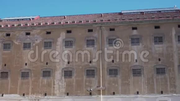 监狱大楼的墙上有窗户和晴空的栏杆视频的预览图