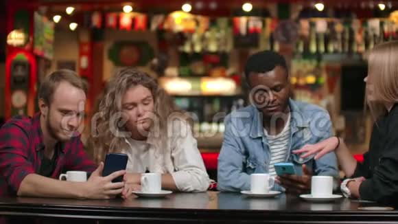多民族夫妇坐在咖啡馆里互相展示照片开怀大笑视频的预览图