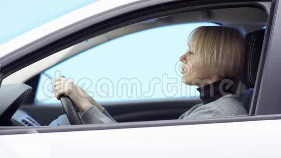 身着便装的金发女子驾驶着绿色屏幕背景的汽车4她正坐在车上喝着酒视频的预览图