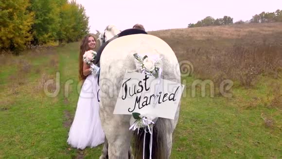 刚结婚的新娘和新郎站在马旁手里拿着刚结婚的铭文视频的预览图