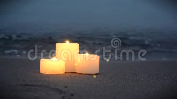 海边沙滩上有三支小蜡烛海浪在燃烧视频的预览图