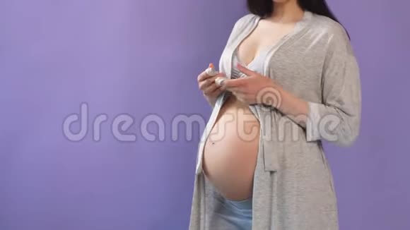 孕妇双手赤腹搭在紫墙上视频的预览图