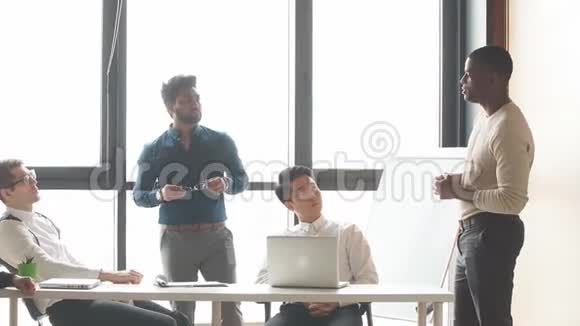 现代公司的多种族男性团队在一个现代化的阁楼办公室进行交流可以看到全景视频的预览图