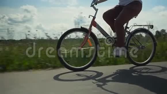 女孩骑着红色自行车在乡下的柏油路上视频的预览图