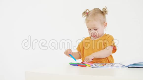 小女孩用蜡笔在白色背景上涂上无法辨认的颜色视频的预览图