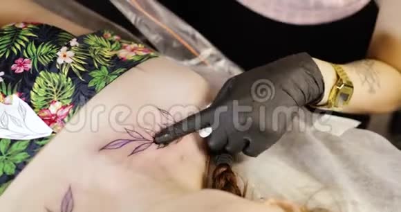 纹身师在沙龙工作时在的肩膀上完成对称纹身视频的预览图