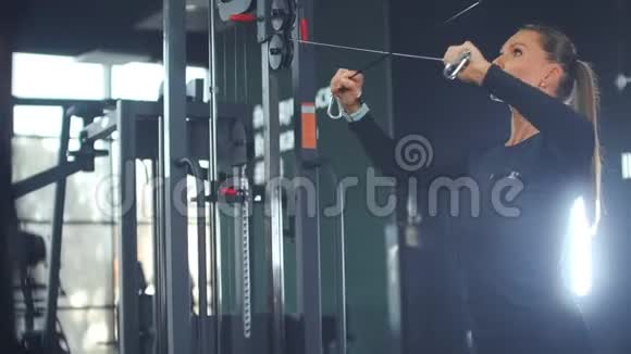 那个女人在健身房里摇动胸部和手臂的肌肉视频的预览图
