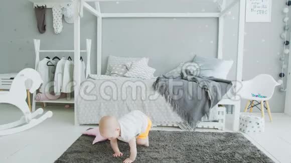 可爱的宝宝想在家里从地板上爬起来视频的预览图
