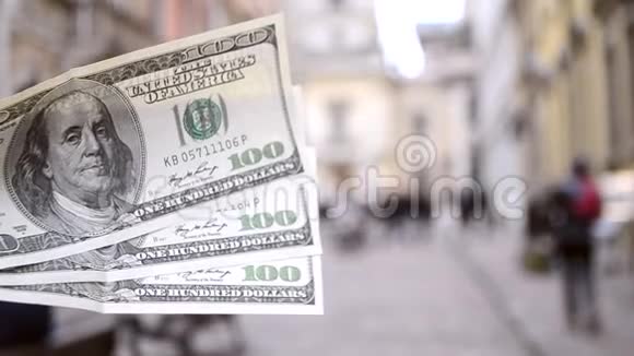 欧洲街头模糊背景下三百美元钞票视频的预览图