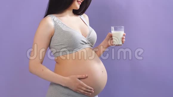 年轻的白人怀孕模特留着一杯牛奶视频的预览图